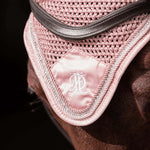 Close up of pink fly veil with pink and diamante trim, modelled on a bay horse, on black background.